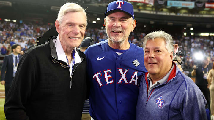 Nov 1, 2023; Phoenix, Arizona, USA; Texas Rangers owner Ray Davis (left), manager Bruce Bochy (center) and COO Neil Leibman (right) pose for a photo after winning the 2023 World Series in five game against the Arizona Diamondbacks at Chase Field. 