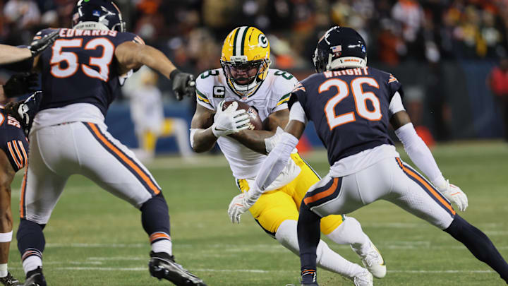 Dec 20, 2025; Chicago, Illinois, USA; Green Bay Packers running back Josh Jacobs (8) runs the ball against Chicago Bears linebacker T.J. Edwards (53) and cornerback Nahshon Wright (26) during the first quarter at Soldier Field. Mandatory Credit: Mike Dinovo-Imagn Images