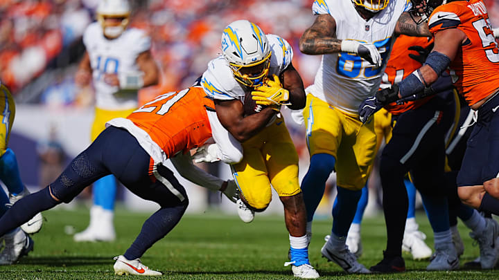 Denver Broncos cornerback Riley Moss reaches for Los Angeles Chargers running back J.K. Dobbins.