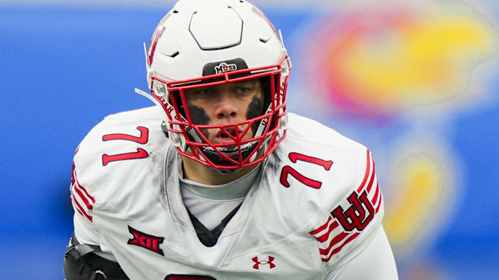 Nov 28, 2025; Lawrence, Kansas, USA; Utah Utes offensive lineman Caleb Lomu (71) gets ready before the snap during the second half against the Kansas Jayhawks at David Booth Kansas Memorial Stadium. Mandatory Credit: Jay Biggerstaff-Imagn Images