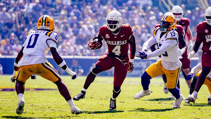 Nov 15, 2025; Baton Rouge, Louisiana, USA;  Arkansas Razorbacks running back Mike Washington (4) runs against LSU Tigers safety Tamarcus Cooley (0) during the first half at Tiger Stadium. Mandatory Credit: Stephen Lew-Imagn Images