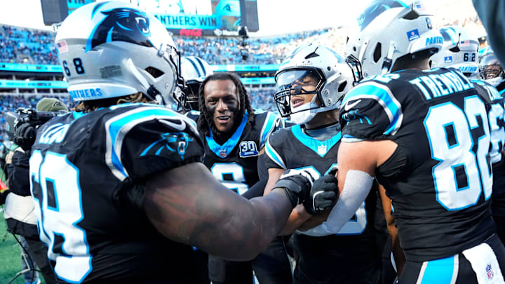 Dec 22, 2024; Charlotte, North Carolina, USA; Carolina Panthers running back Chuba Hubbard (30) celebrates with guard Damien Lewis (68) and cornerback Jaycee Horn (8) and tight end Tommy Tremble (82) after scoring a touchdown to win the game in overtime at Bank of America Stadium. 