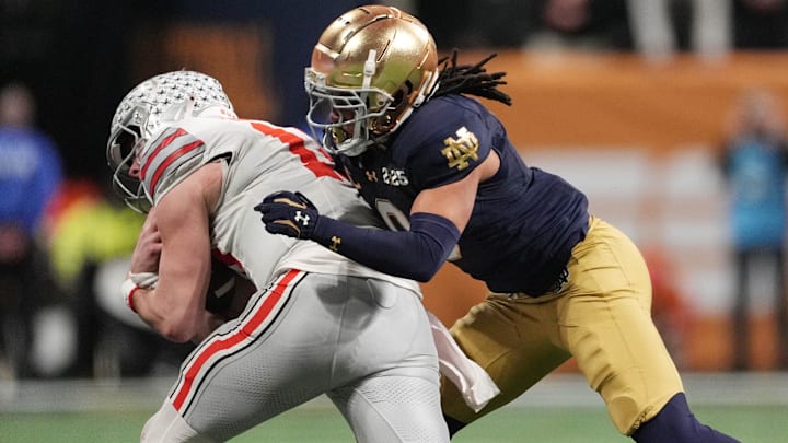 Jan 20, 2025; Atlanta, GA, USA; Notre Dame Fighting Irish safety Xavier Watts (0) tackles Ohio State Buckeyes quarterback Will Howard (18) in the second half in the CFP National Championship college football game at Mercedes-Benz Stadium. Mandatory Credit: Dale Zanine-Imagn Images