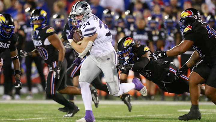 Kansas State junior tight end Ben Sinnott (34) drives through Kansas defenders during the first half.
