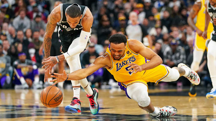 Former Los Angeles Lakers guard Talen Horton-Tucker (5) dives under San Antonio Spurs guard Dejounte Murray (5) for a loose ball in the first half at the AT&T Center.