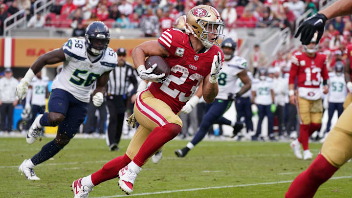 Nov 17, 2024; Santa Clara, California, USA; San Francisco 49ers running back Christian McCaffrey (23) rushes the ball while be pursued by Seattle Seahawks linebacker Derick Hall (58) in the fourth quarter at Levi's Stadium. Mandatory Credit: David Gonzales-Imagn Images