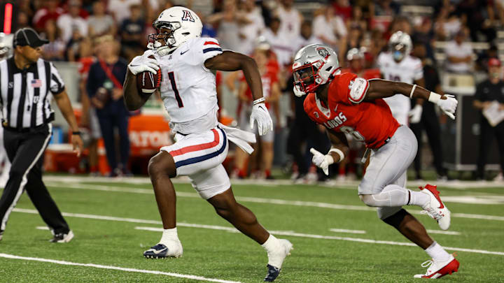 Aug 31, 2024; Tucson, Arizona, USA; Arizona Wildcats running back Jacory Croskey-Merritt (1) runs the ball for a touchdown while New Mexico Lobos safety Christian Ellis (8) chases him during fourth quarter at Arizona Stadium. Aug 31, 2024; Tucson, Arizona, USA; Arizona Wildcats running back Jacory Croskey-Merritt (1) runs the ball for a touchdown while New Mexico Lobos safety Christian Ellis (8) chases him during fourth quarter at Arizona Stadium.
