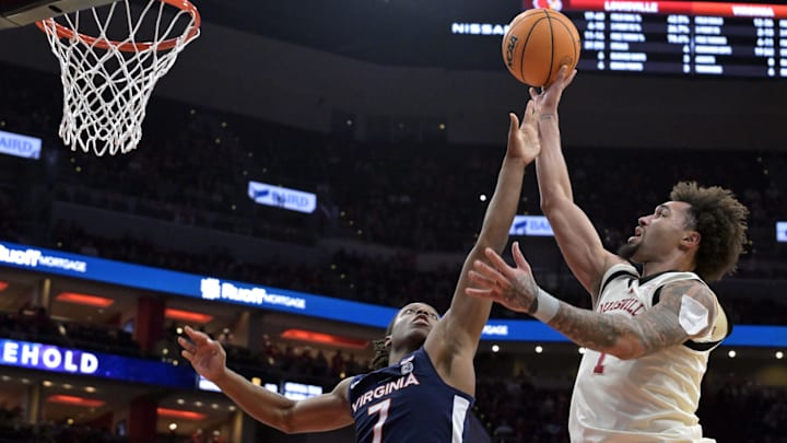 Jan 18, 2025; Louisville, Kentucky, USA;  Louisville Cardinals guard J'Vonne Hadley (1) shoots against Virginia Cavaliers guard Dai Dai Ames (7) during the second half at KFC Yum! Center. Louisville defeated Virginia 81-67. Mandatory Credit: Jamie Rhodes-Imagn Images