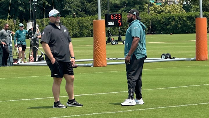 Joe Douglas chats with assistant OL coach Greg Austin during OTAs.