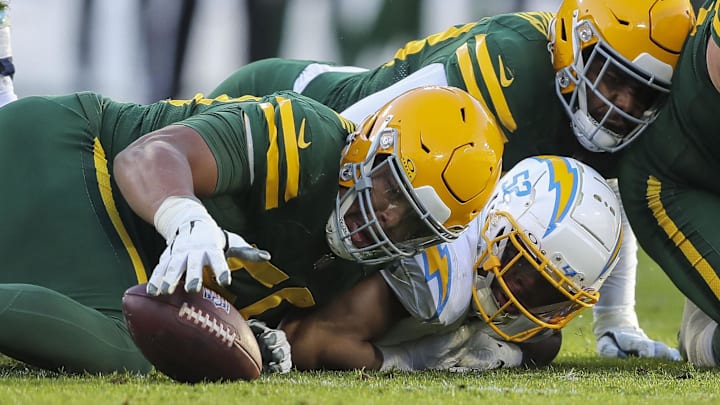 Green Bay Packers lineman Zach Tom (50) recovers a fumble forced by Los Angeles Chargers linebacker Khalil Mack in 2023.