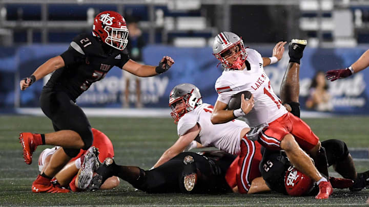 Lake Mary quarterback Noah Grubbs (13) fights for yardage against Vero Beach in the Class 7A state title game Saturday, Dec. 13, 2025, at FIU in Miami. Grubbs threw a Hail Mary pass on the final play of the game to lead the Rams past the Indians, 28-27. Lake Mary quarterback Noah Grubbs (13) fights for yardage against Vero Beach in the Class 7A state title game Saturday, Dec. 13, 2025, at FIU in Miami. Grubbs threw a Hail Mary pass on the final play of the game to lead the Rams past the Indians, 28-27.