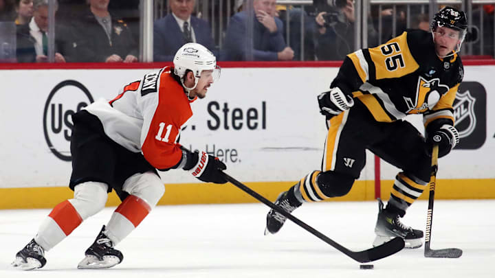 Dec 23, 2024; Pittsburgh, Pennsylvania, USA;  Philadelphia Flyers right wing Travis Konecny (11) moves the puck against Pittsburgh Penguins center Noel Acciari (55) during the third period at PPG Paints Arena. Mandatory Credit: Charles LeClaire-Imagn Images