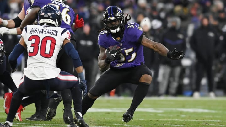 Jan 20, 2024; Baltimore, MD, USA; Baltimore Ravens running back Gus Edwards (35) runs the ball against Houston Texans safety DeAndre Houston-Carson (30) during the second quarter  in a 2024 AFC divisional round game at M&T Bank Stadium. Mandatory Credit: Tommy Gilligan-USA TODAY Sports