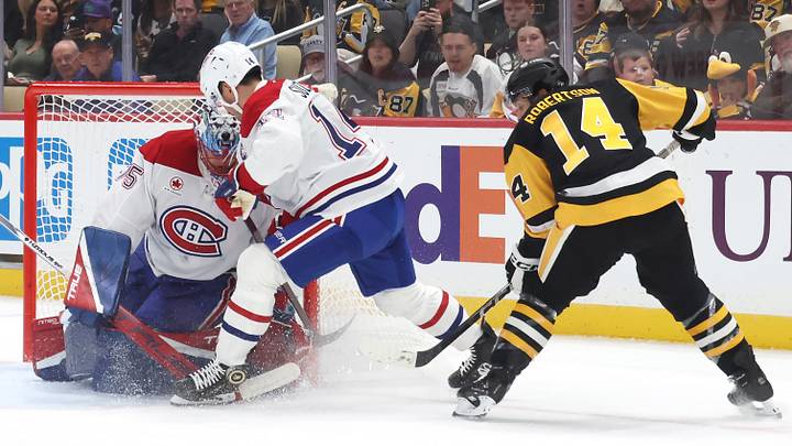 Montreal Canadiens goaltender Jakub Dobes (75) and center Nick Suzuki (14) defend a shot by Pittsburgh Penguins left wing Nick Robertson (14) during the first period at PPG Paints Arena.  Mandatory Credit: Charles LeClaire-Imagn Images