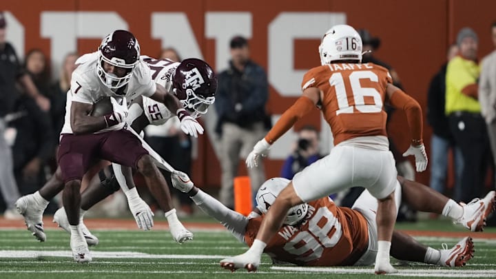 Texas A&M Aggies wide receiver KC Concepcion (7) runs for yards while having his shirt tugged on by Texas Longhorns Maraad Watson (98).