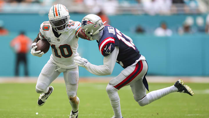 Oct 29, 2023; Miami Gardens, Florida, USA; Miami Dolphins wide receiver Tyreek Hill (10) runs with the football against New England Patriots cornerback Jack Jones (13) during the second quarter at Hard Rock Stadium. Mandatory Credit: Sam Navarro-Imagn Images