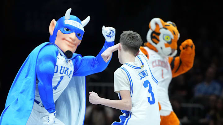 Duke Blue Devils mascot and a fan in a dance off against the Clemson Tiger.