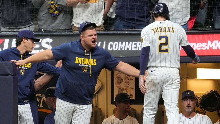 Milwaukee Brewers hitting coach Daniel Vogelbach congratulates second baseman Brice Turang.