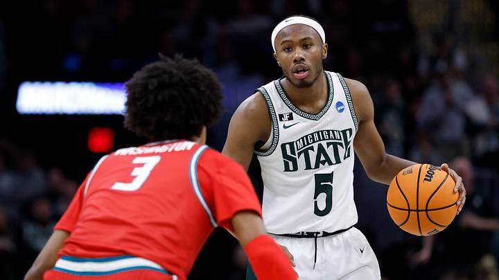Mar 23, 2025; Cleveland, OH, USA; Michigan State Spartans guard Tre Holloman (5) dribbles defended by New Mexico Lobos guard Tru Washington (3) in the first half during the NCAA Tournament Second Round at Rocket Arena. Mandatory Credit: Rick Osentoski-Imagn Images