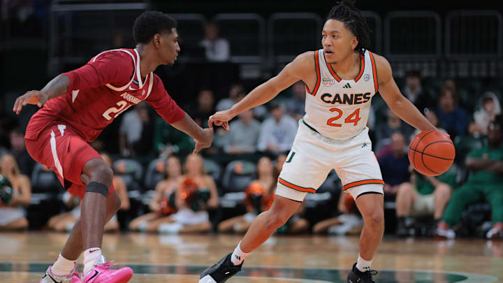 Dec 3, 2024; Coral Gables, Florida, USA; Miami Hurricanes guard Nijel Pack (24) dribblers the basketball as Arkansas Razorbacks forward Billy Richmond III (24) defends during the second half at Watsco Center. Mandatory Credit: Sam Navarro-Imagn Images
