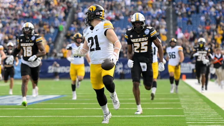 Dec 30, 2024; Nashville, TN, USA;  Iowa Hawkeyes wide receiver Kaden Wetjen (21) returns a kickoff for a touchdown against the Missouri Tigers during the first half at Nissan Stadium. Mandatory Credit: Steve Roberts-Imagn Images