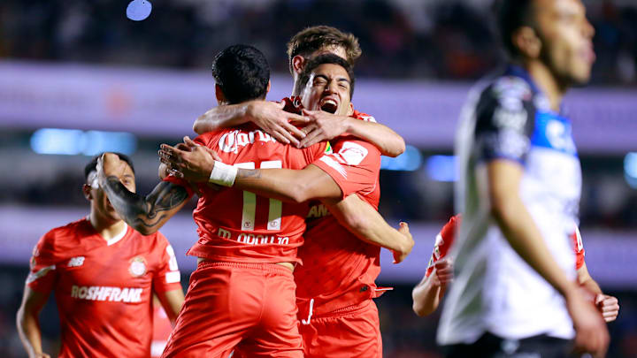 Maxi Araujo (No. 11) celebrates with Federico Pereira and Marcel Ruiz after Pereira (facing camera) netted the tying goal for Toluca in their season opener at Querétaro.