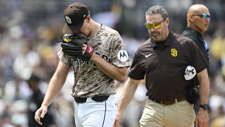 Apr 12, 2026; San Diego, California, USA; San Diego Padres starting pitcher Nick Pivetta (27), left, leaves the field with a trainer during the fourth inning against the Colorado Rockies at Petco Park. Mandatory Credit: Denis Poroy-Imagn Images