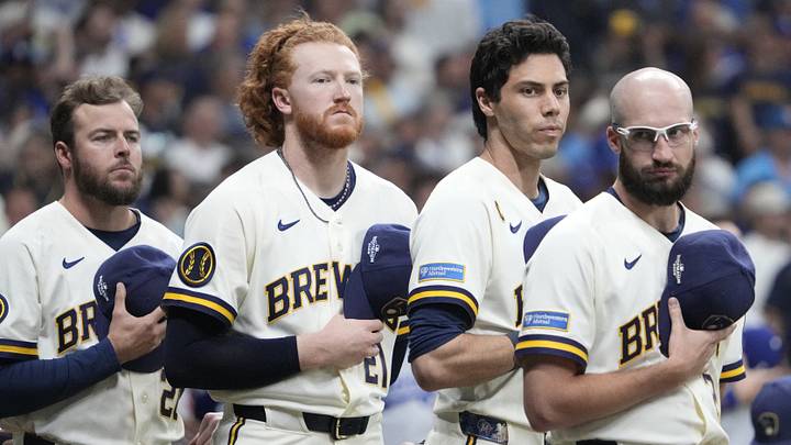 Oct 11, 2026; Milwaukee, Wisconsin, USA; Milwaukee Brewers pitcher Dustin May (21), designated hitter Christian Yelich (22), and pitcher Aaron Ashby (26) stand for the National Anthem prior to game one of the NLCS for the 2026 MLB Playoffs against the Los Angeles Dodgers at American Family Field. Mandatory Credit: Michael McLoone-Imagn Images Oct 11, 2026; Milwaukee, Wisconsin, USA; Milwaukee Brewers pitcher Dustin May (21), designated hitter Christian Yelich (22), and pitcher Aaron Ashby (26) stand for the National Anthem prior to game one of the NLCS for the 2026 MLB Playoffs against the Los Angeles Dodgers at American Family Field. Mandatory Credit: Michael McLoone-Imagn Images