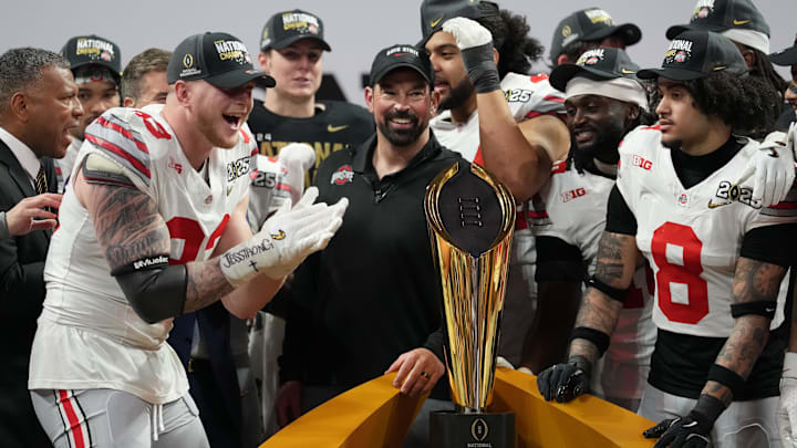 Jan 20, 2025; Atlanta, GA, USA; Ohio State Buckeyes defensive end Jack Sawyer (33) and Ohio State Buckeyes head coach Ryan Day celebrate on the podium after defeating the Notre Dame Fighting Irish in the CFP National Championship college football game at Mercedes-Benz Stadium. Mandatory Credit: Kirby Lee-Imagn Images