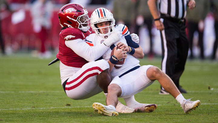 Nov 11, 2023; Fayetteville, Arkansas, USA;  Arkansas Razorbacks defensive lineman Trajan Jeffcoat (7) sacks Auburn Tigers quarterback Payton Thorne (1) during the second quarter at Donald W. Reynolds Razorback Stadium. Mandatory Credit: Brett Rojo-Imagn Images