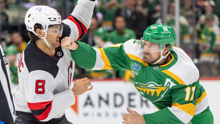 Mar 29, 2025; Saint Paul, Minnesota, USA; New Jersey Devils defenseman Johnathan Kovacevic (8) catches a right hand to the chin from Minnesota Wild left wing Marcus Foligno (17) during fight in the second period at Xcel Energy Center. Mandatory Credit: Matt Blewett-Imagn Images