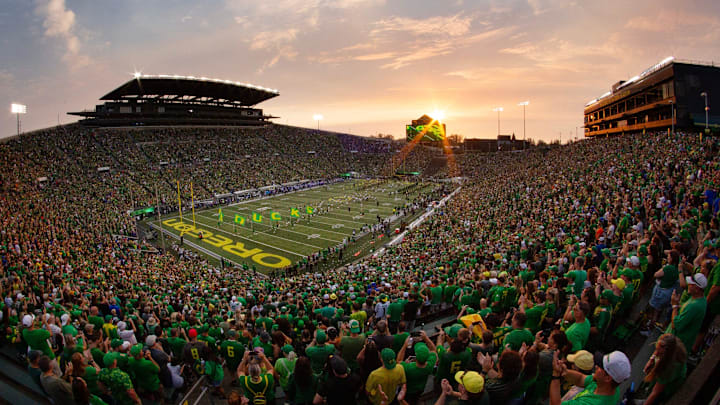 The sun sets over Autzen Stadium as Oregon players and cheerleaders take the field for the game against Boise State in Eugene Sept. 7, 2024.