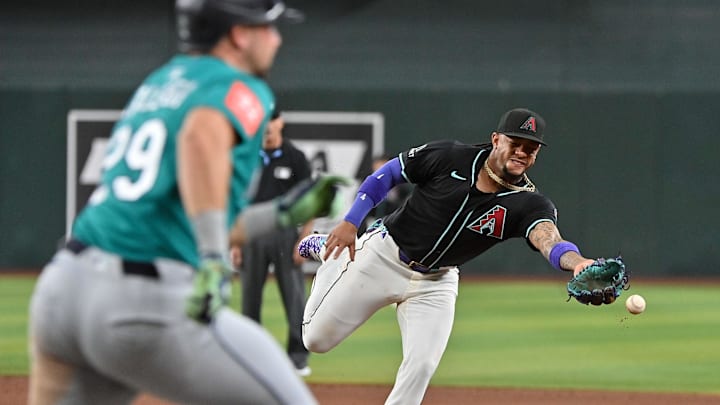 Jun 11, 2025; Phoenix, Arizona, USA;  Arizona Diamondbacks second base Ketel Marte (4) tosses the ball to first baseman as Seattle Mariners catcher Cal Raleigh (29) beats him in the third inning at Chase Field. Mandatory Credit: Matt Kartozian-Imagn Images