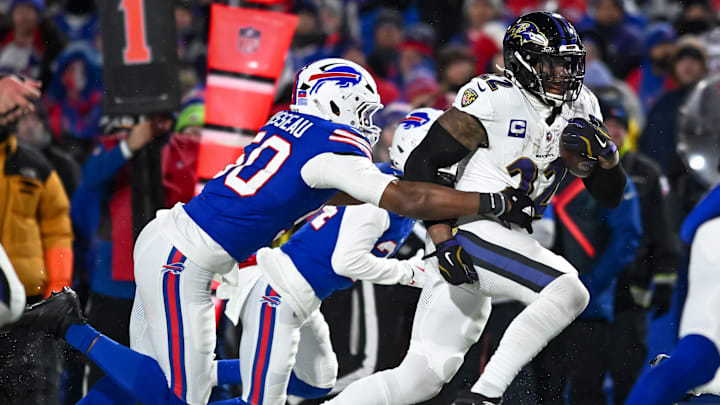 Jan 19, 2025; Orchard Park, New York, USA; Baltimore Ravens running back Derrick Henry (22) carries the ball as Buffalo Bills defensive end Greg Rousseau (50) attempts a tackle in the third quarter of a 2025 AFC divisional round game at Highmark Stadium. Mandatory Credit: Mark Konezny-Imagn Images