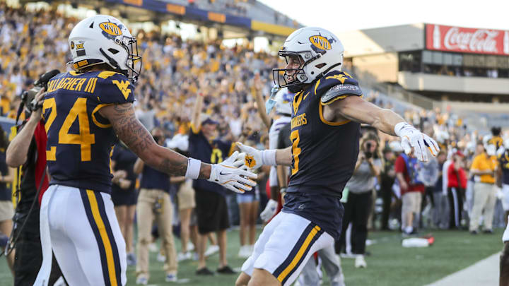 West Virginia Mountaineers wide receiver Rodney Gallagher III (24) celebrates with West Virginia Mountaineers wide receiver Hudson Clement (3) after catching a pass for a touchdown late during the fourth quarter against the Kansas Jayhawks at Mountaineer Field at Milan Puskar Stadium.