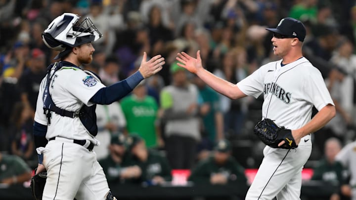 Aug 28, 2023; Seattle, Washington, USA; Seattle Mariners catcher Brian O'Keefe (64) and relief pitcher Trent Thornton (46) celebrate defeating the Oakland Athletics during the ninth inning at T-Mobile Park. Mandatory Credit: Steven Bisig-Imagn Images