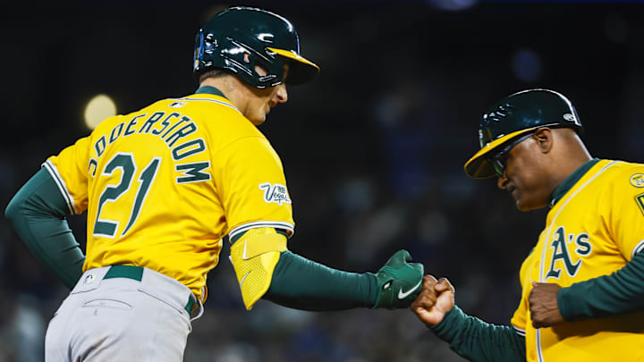 Mar 27, 2025; Seattle, Washington, USA; Athletics first baseman Tyler Soderstrom (21) bumps fists with third base coach Eric Martins (3) after hitting a solo-home run against the Seattle Mariners during the eighth inning at T-Mobile Park. Mandatory Credit: Joe Nicholson-Imagn Images