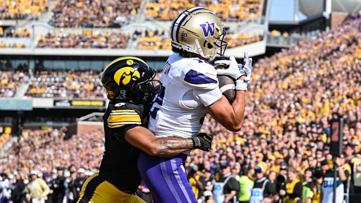 Huskies wide receiver Denzel Boston (12) catches a touchdown pass as Iowa defensive back Deshaun Lee (8) can't stop it. Huskies wide receiver Denzel Boston (12) catches a touchdown pass as Iowa defensive back Deshaun Lee (8) can't stop it.