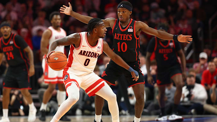 Dec 20, 2025; Phoenix, Arizona, USA; Arizona Wildcats guard Jaden Bradley (0) controls the ball against San Diego State Aztecs guard BJ Davis (10) during the Hall of Fame Series at Mortgage Matchup Center. Mandatory Credit: Mark J. Rebilas-Imagn Images