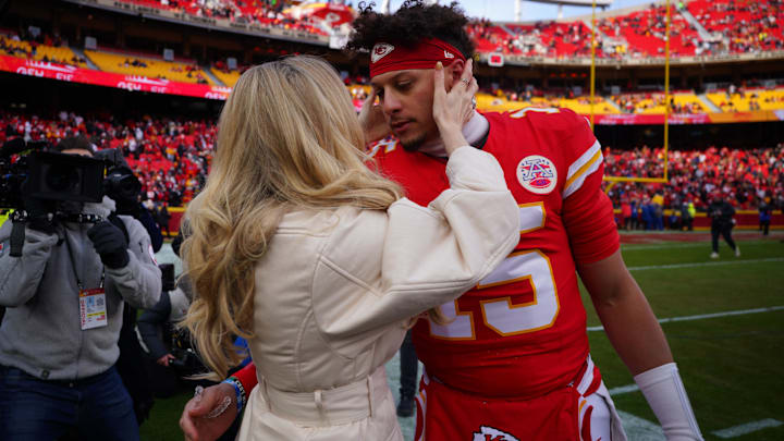 Kansas City Chiefs quarterback Patrick Mahomes (15) kisses his wife Brittany Mahomes before a 2025 AFC divisional round game against the Houston Texans at GEHA Field at Arrowhead Stadium.