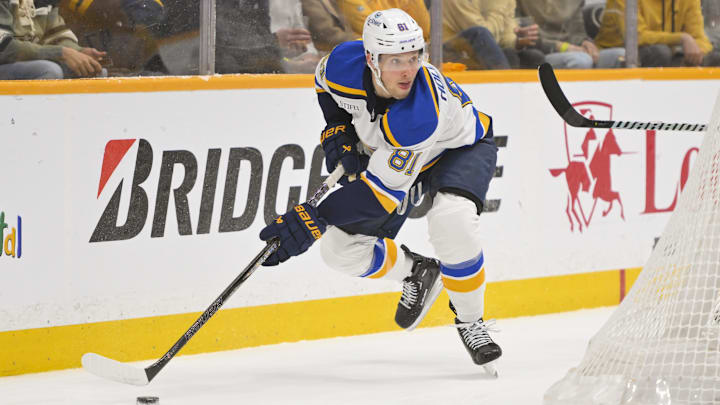 Mar 18, 2025; Nashville, Tennessee, USA;  St. Louis Blues center Dylan Holloway (81) skates behind the net against the Nashville Predators during the first period at Bridgestone Arena. Mandatory Credit: Steve Roberts-Imagn Images