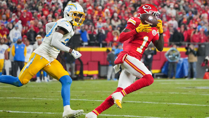 Dec 8, 2024; Kansas City, Missouri, USA; Kansas City Chiefs wide receiver Xavier Worthy (1) runs the ball as Los Angeles Chargers cornerback Cam Hart (20) defends during the first half at GEHA Field at Arrowhead Stadium. Mandatory Credit: Denny Medley-Imagn Images