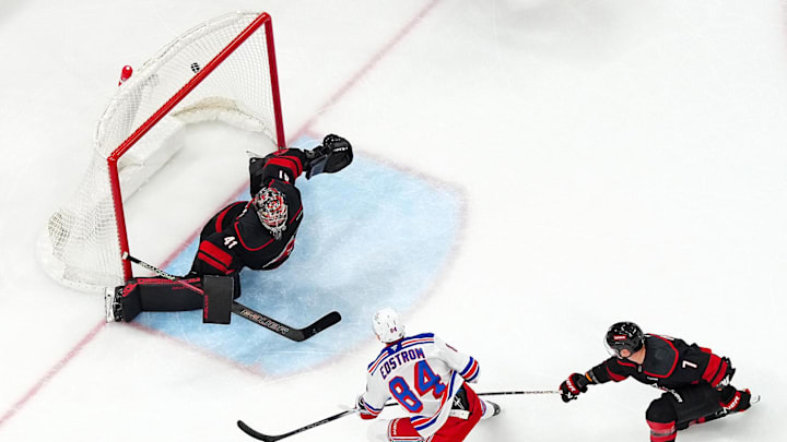 Nov 27, 2024; Raleigh, North Carolina, USA;  New York Rangers center Adam Edstrom (84) scores a goal past Carolina Hurricanes goaltender Spencer Martin (41) and  defenseman Dmitry Orlov (7) during the second period at Lenovo Center. Mandatory Credit: James Guillory-Imagn Images