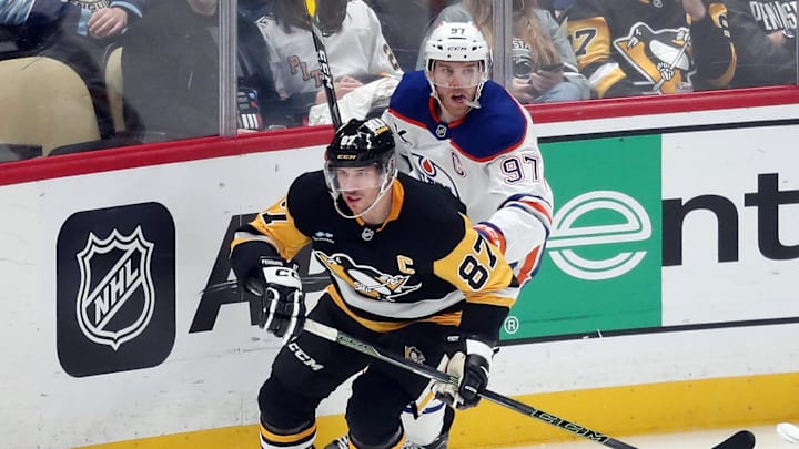 Jan 9, 2025; Pittsburgh, Pennsylvania, USA;  Pittsburgh Penguins center Sidney Crosby (87) and Edmonton Oilers center Connor McDavid (97) chase the puck during the third period at PPG Paints Arena. Mandatory Credit: Charles LeClaire-Imagn Images