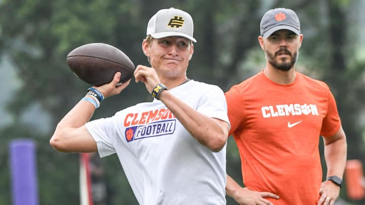 Brady Hart, left, of Cocoa Florida passes near Clemson offensive coordinator Garrett Riley during the 2024 Dabo Swinney Football Camp in Clemson in Clemson June 5, 2024.