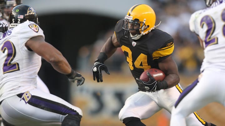 Dec 27, 2009; Pittsburgh, PA, USA; Pittsburgh Steelers running back Rashard Mendenhall (34) runs the ball between Baltimore Ravens linebacker Ray Lewis (52) and safety Tom Zbikowski (28) during the second half of the game at Heinz Field. The Steelers won the game, 23-20. Mandatory Credit: Jason Bridge-Imagn Images