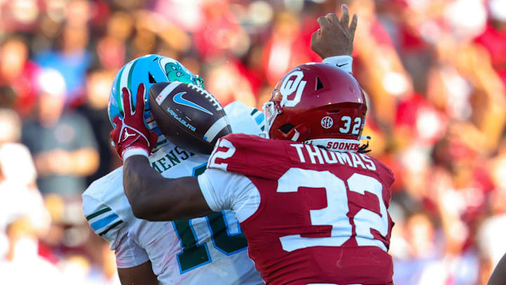 Oklahoma defensive end R Mason Thomas dislodges the football from Tulane quarterback Darian Mensah.