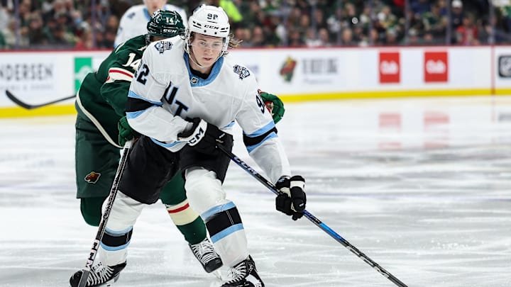 Jan 23, 2025; Saint Paul, Minnesota, USA; Utah Hockey Club center Logan Cooley (92) skates with the puck as Minnesota Wild center Joel Eriksson Ek (14) defends during the third period at Xcel Energy Center. Mandatory Credit: Matt Krohn-Imagn Images