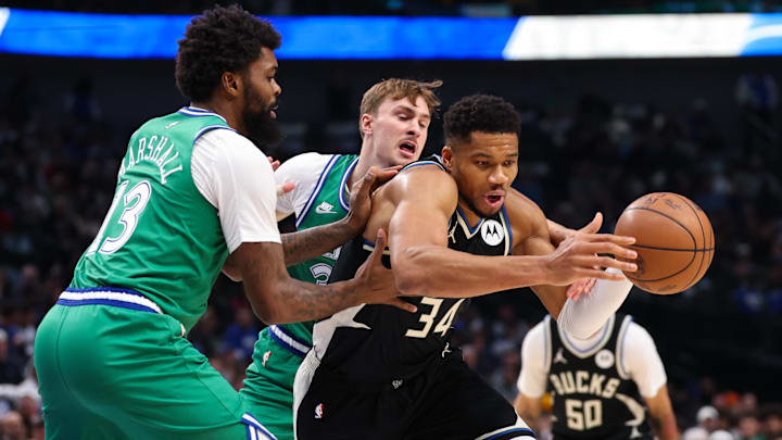 Nov 10, 2025; Dallas, Texas, USA; Milwaukee Bucks forward Giannis Antetokounmpo (34) tries to control the ball as Dallas Mavericks forward Cooper Flagg (32) and Dallas Mavericks forward Naji Marshall (13) defend during the first quarter at American Airlines Center. Mandatory Credit: Kevin Jairaj-Imagn Images