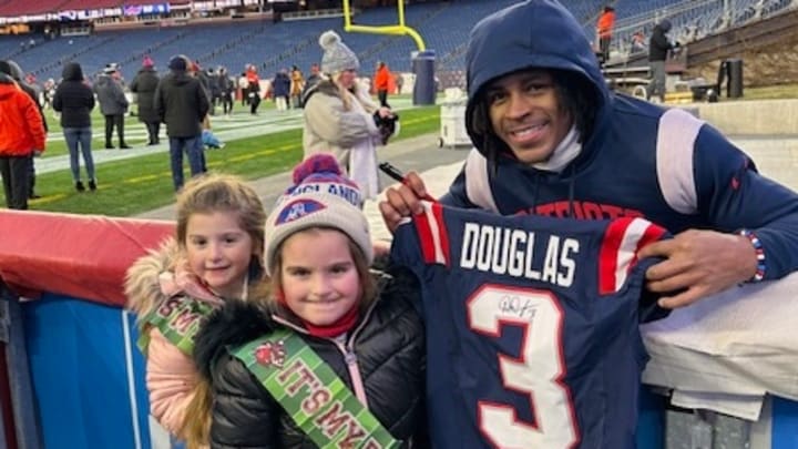 New England Patriots wide receiver DeMario Douglas gifts a signed jersey to 7-year-old super fan Riley Tardiff earlier this season.